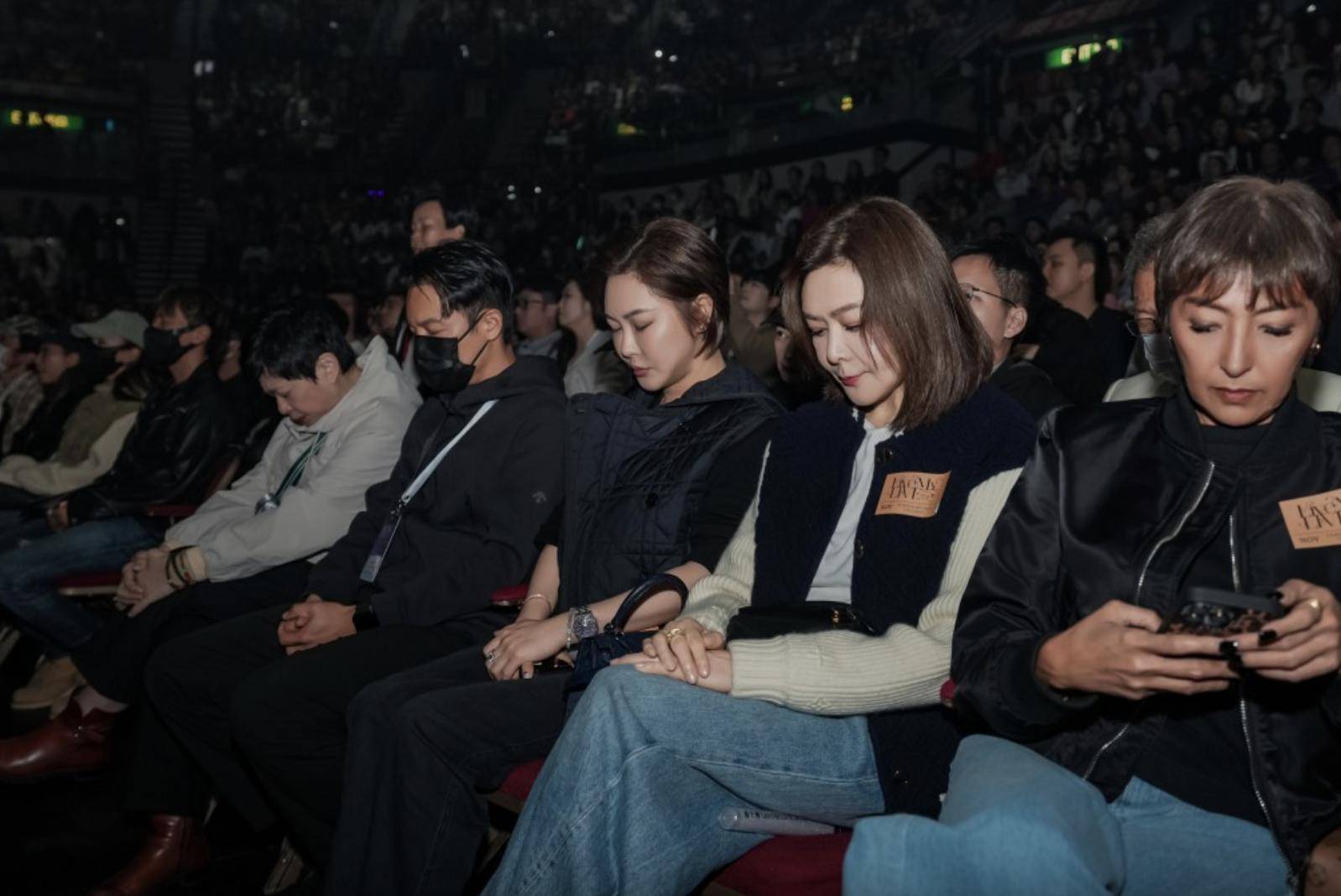 关之琳看演出为火灾默哀，低头坐着表情凝重，上山诗钠在旁看手机