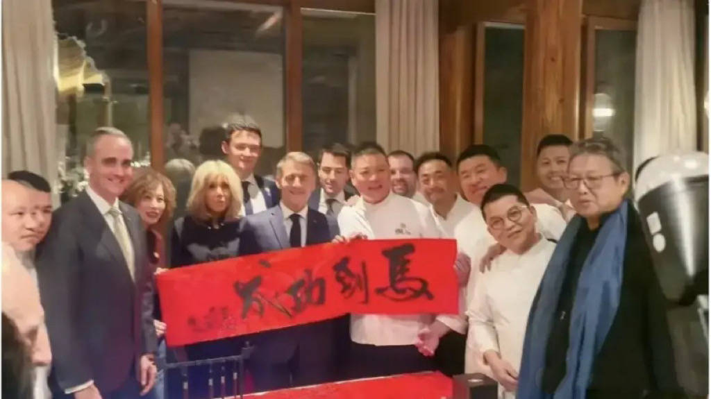 巩俐陪马克龙夫妇吃烤鸭，穿黑衣扎丸子头气场强，快六十岁还很美