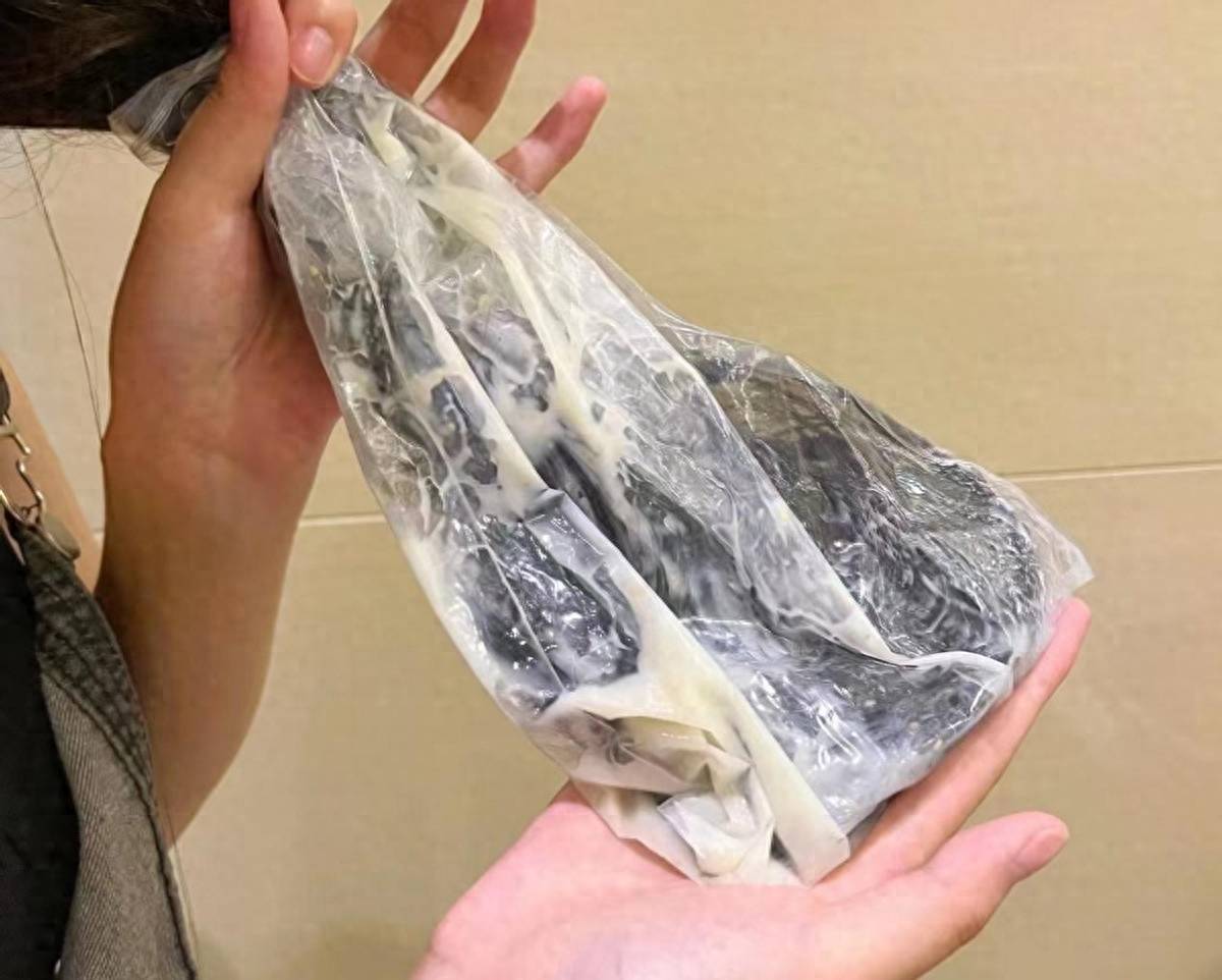 在手心挤适量护发素或发膜,搓开后均匀涂抹在头发上,用保鲜膜包裹