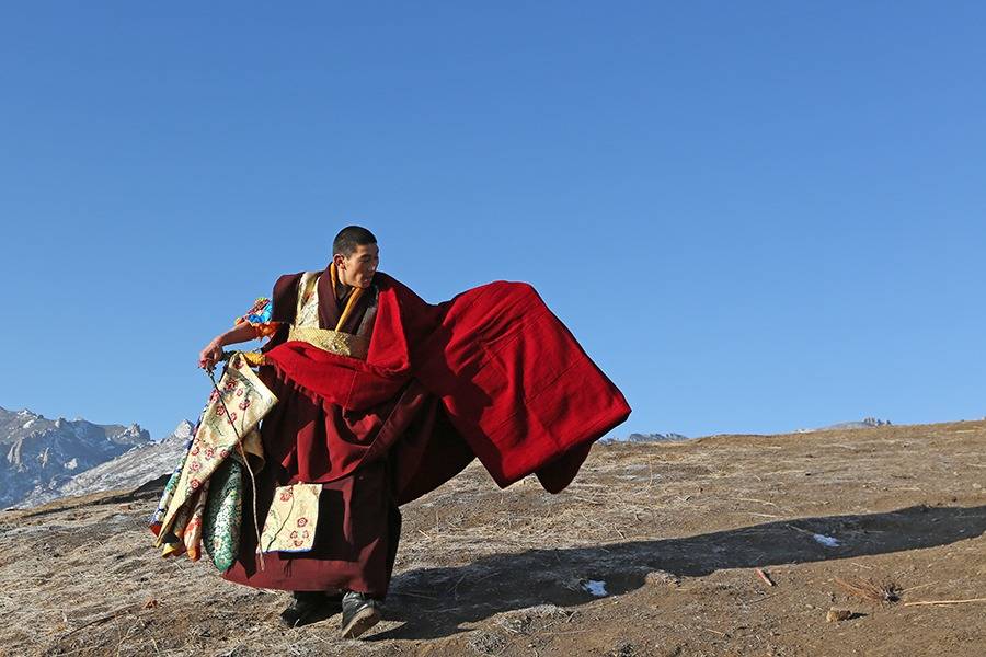 编辑到了晒佛台,僧人把唐卡推到铁架的最高处固定后,佛祖随着唐卡的