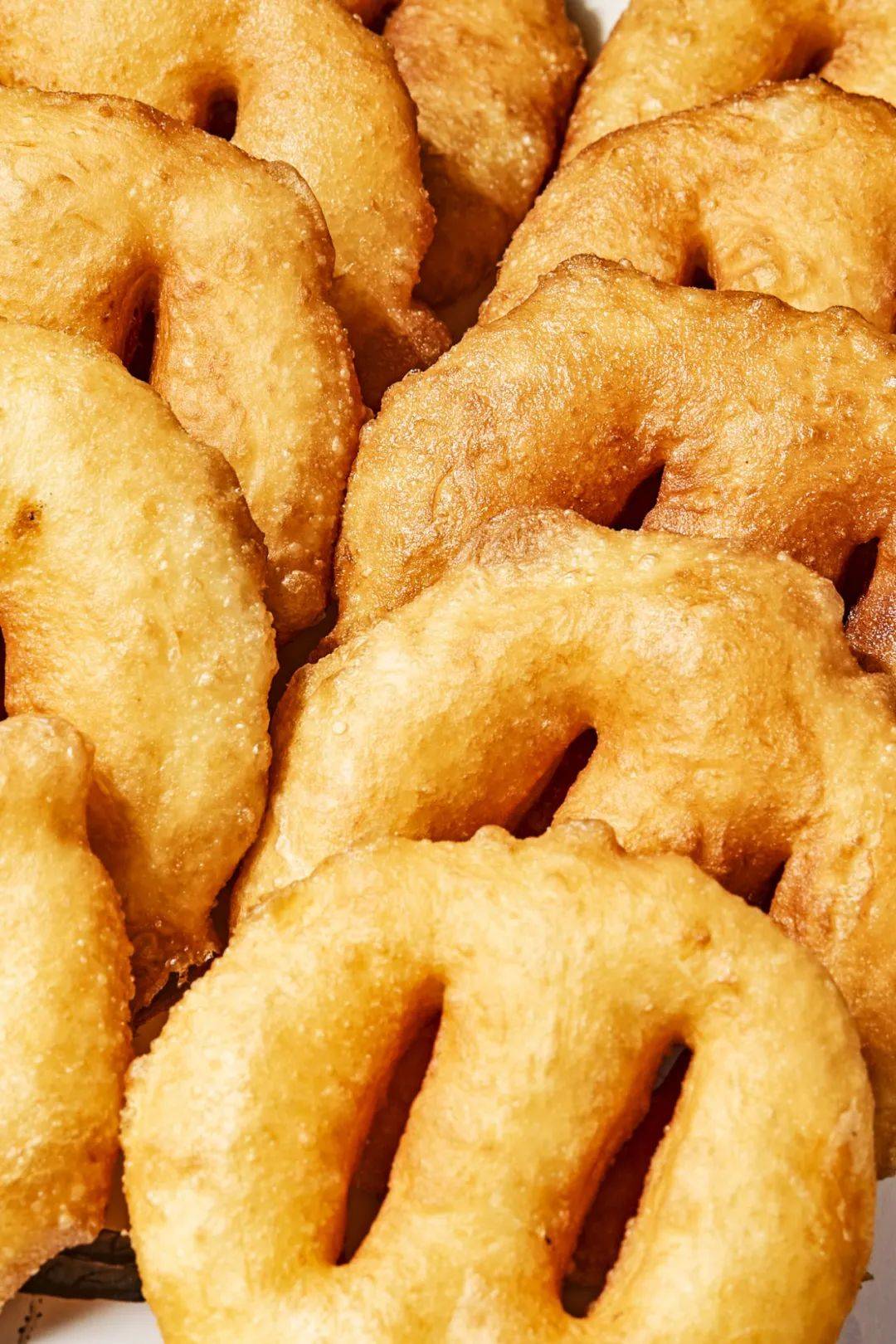 首先,要炸待客送礼必不可少的油饼,朴实无华的面饼中间划上两刀下锅