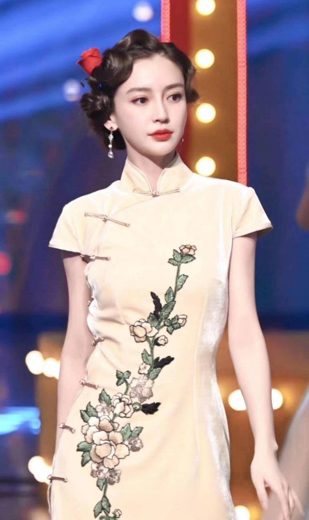 穿着淡黄色的丝绒旗袍,精致的脸庞,忧伤的表情让人看了都忍俊不禁