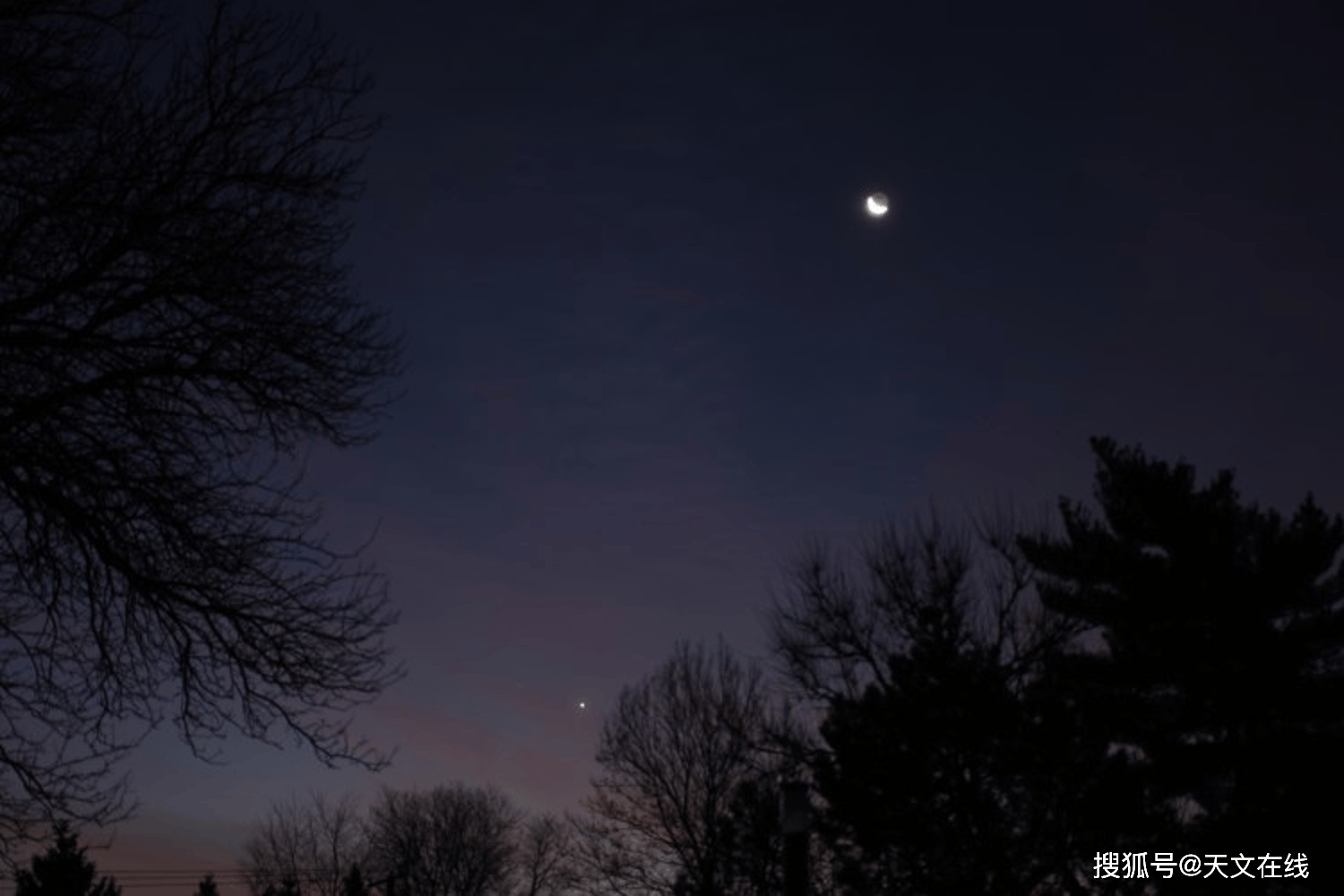 图片说明 — 2020年十二月11日:日出前一小时,一轮新月位于晨间明亮的