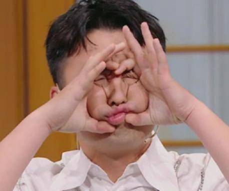 董子健做出鬼脸,双手抱住脸,一只手向上用力,另一只手向下用力,表情