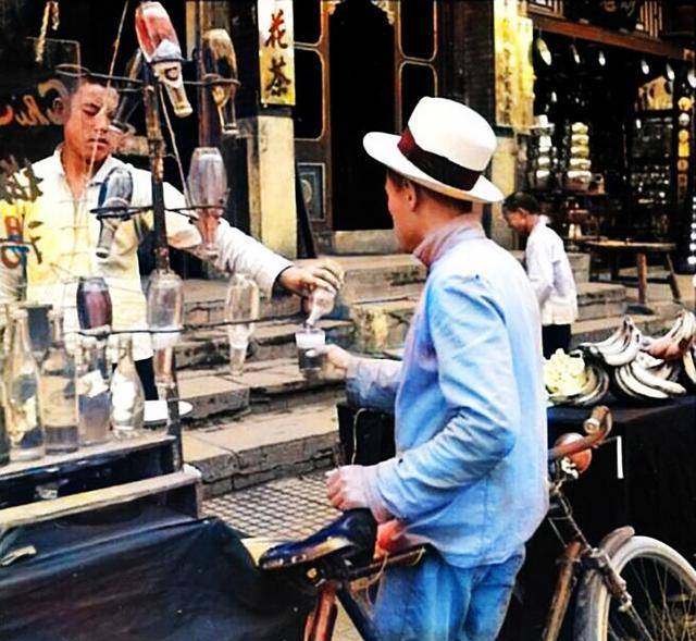 1939年夏天的北京前门,母女坐地休息纳凉,男孩吃冰棍消暑解渴