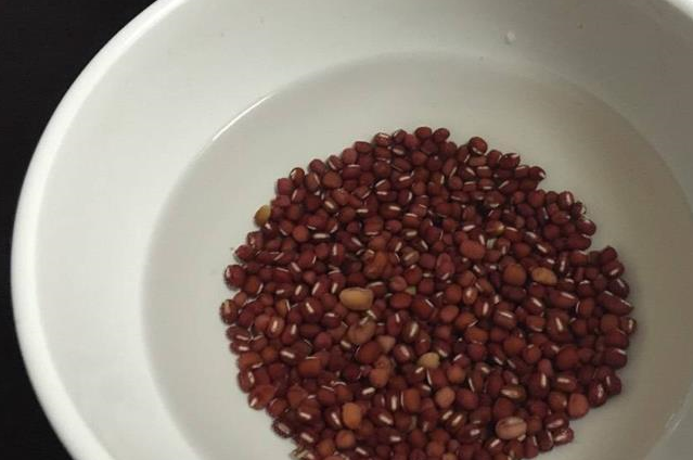 红豆以及淘洗干净的红米,大米放入电饭锅中,随后加入桂圆干和红皮花生