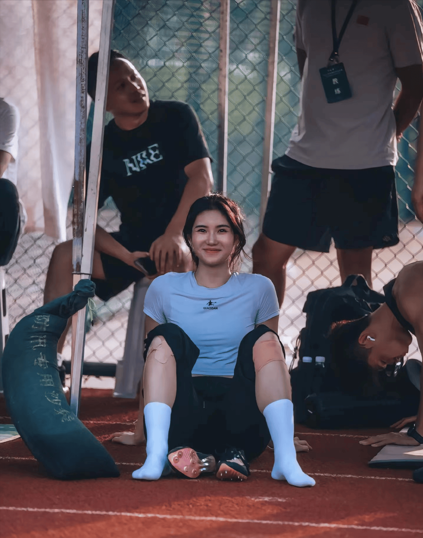 阳光下的她,身着紧身运动服,身材线条流畅而优美,每一次跨栏都显得