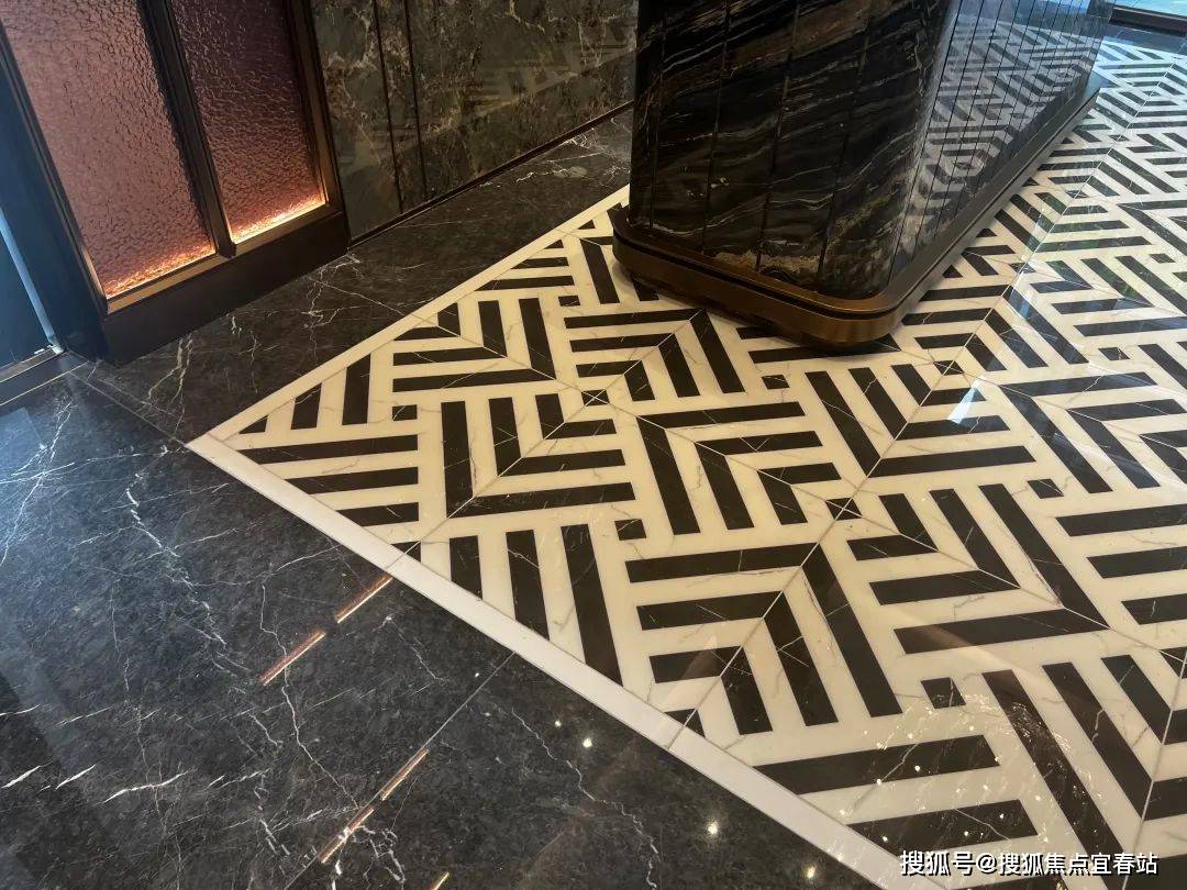 大量的石材拼接,超大的玻璃吊灯,背景墙深色系的大理石和金属的切