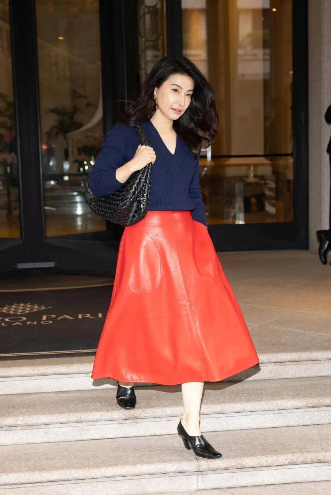 她就凭借一身藏蓝针织和正红皮裙的撞色look吸睛,精致的大波浪发型,看