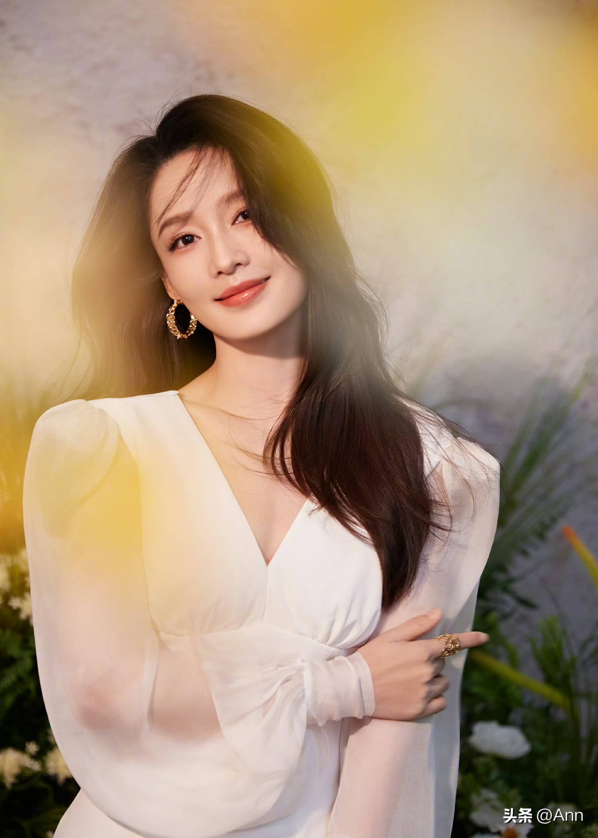 李沁穿着白色露肩长裙置身花海,阳光洒在身上笑容甜美