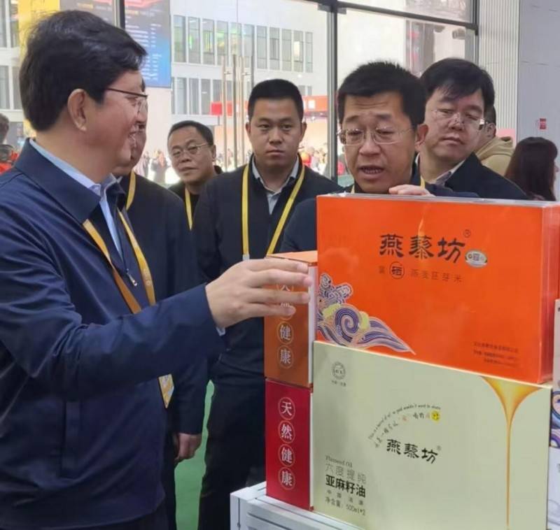 沽源县委书记赵赞为河北省供销合作总社党组书记王建军介绍"燕藜坊"