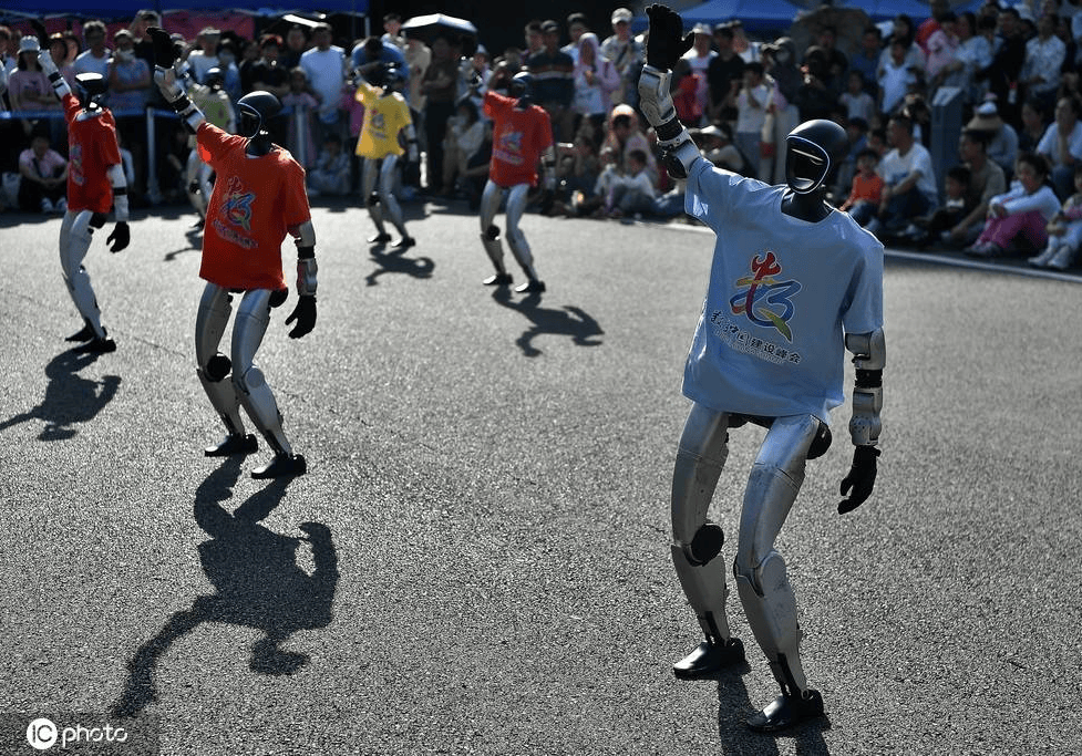 具身智能机器人舞团展演吸引市民围观_科技_赞叹声_会徽