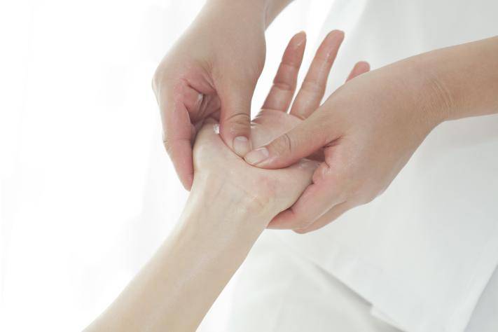 The beautician who massages a hand