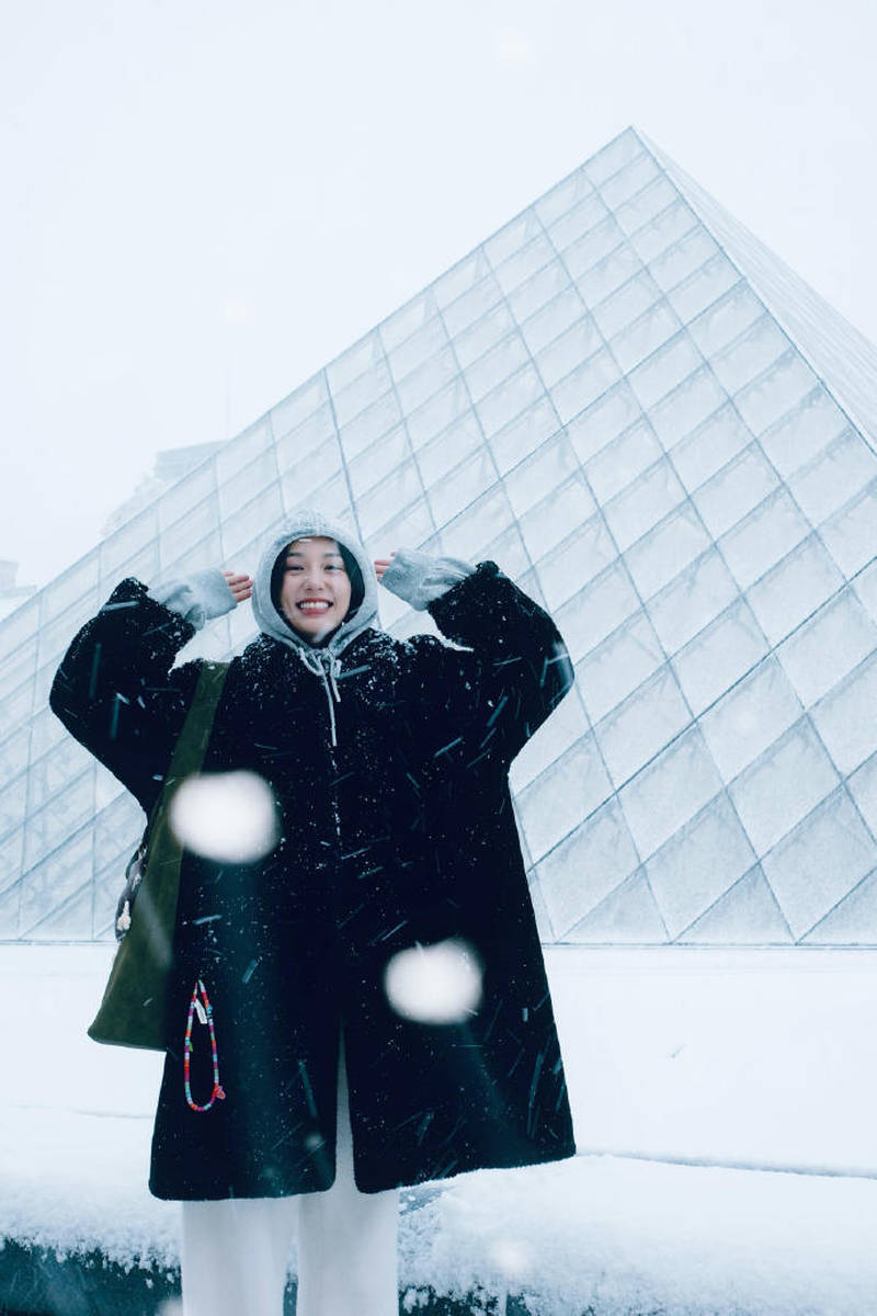 周也晒法国看雪照笑容灿烂 穿黑色大衣五官精致