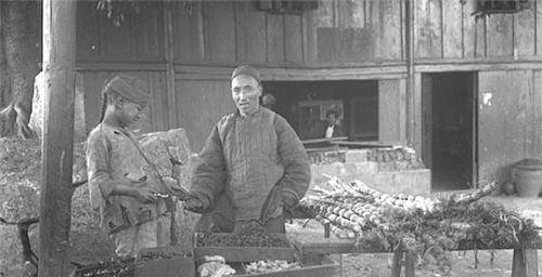 人是一个水果商贩,可以看出他摆放水果的架子比较老旧,右边的甘蔗还好