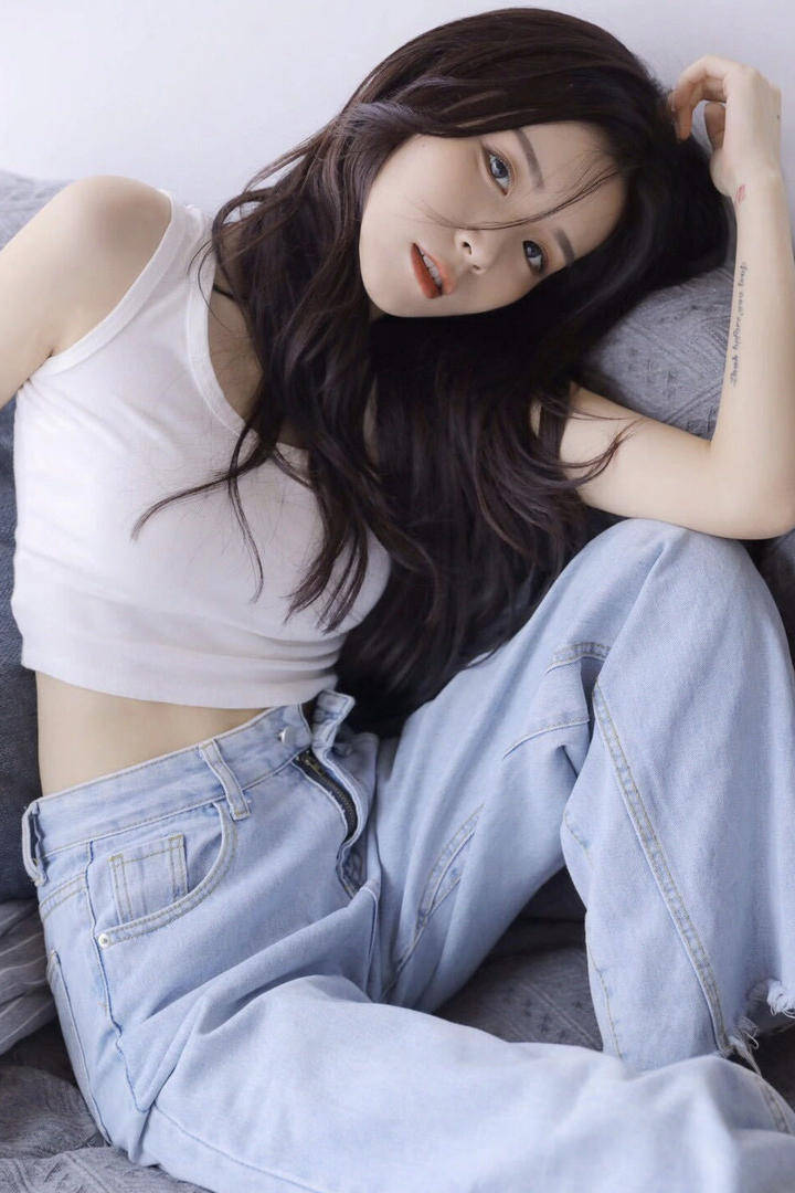 坐在沙发上的清纯牛仔裤女生写真无水印手机壁纸