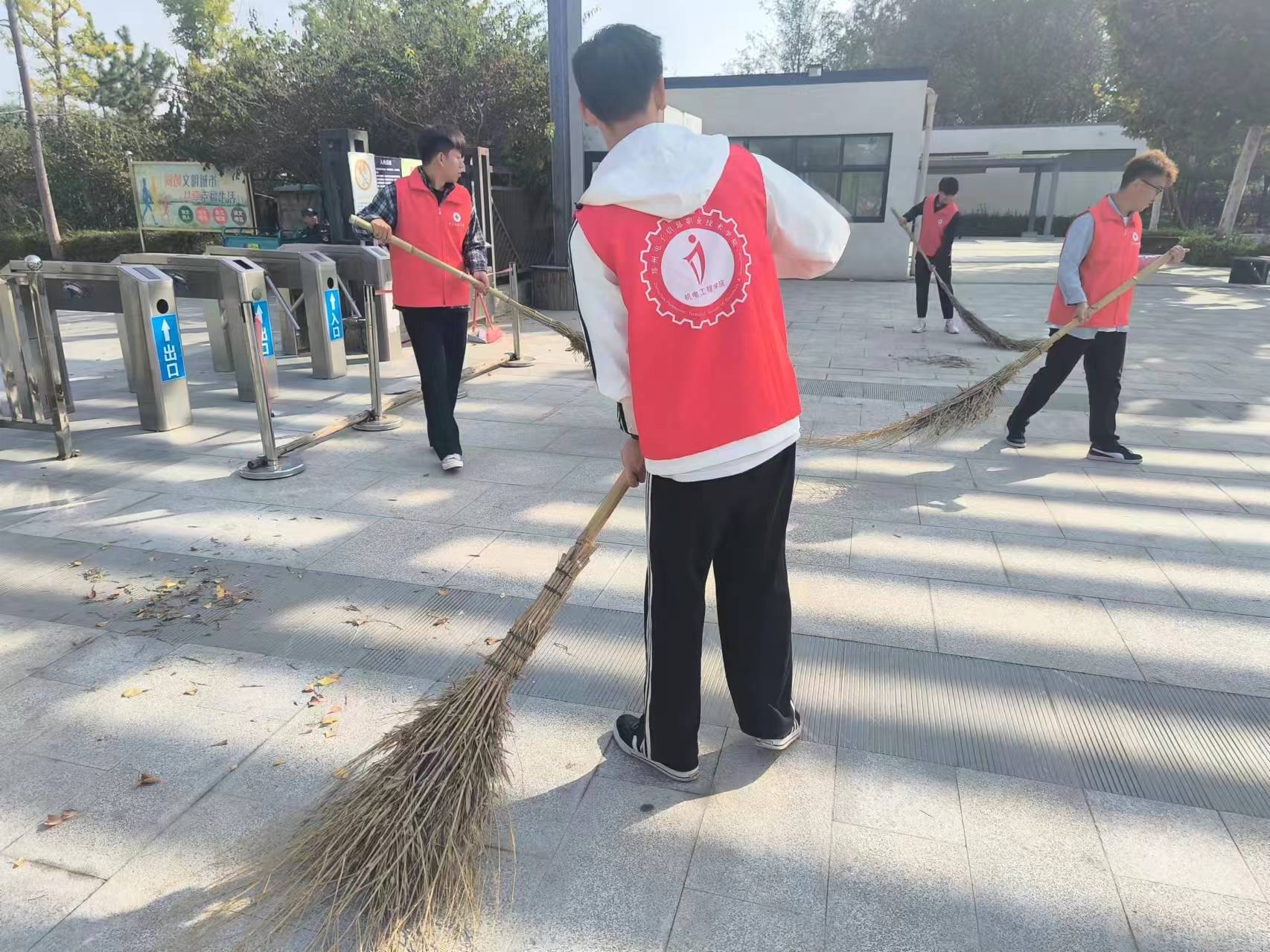 活动中,社区工作人员和志愿者们身穿红色小马甲,手拿扫把,夹子等清洁