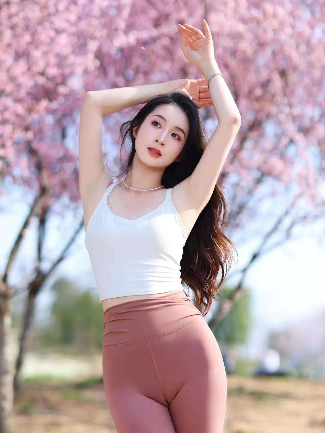 街拍亮点·桃园倩影:长发飘飘的小姐姐穿着红色紧身瑜伽裤漫步在桃林