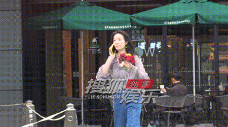 齐溪手拿一束鲜花边走路边打电话 风吹起头发又随性又美