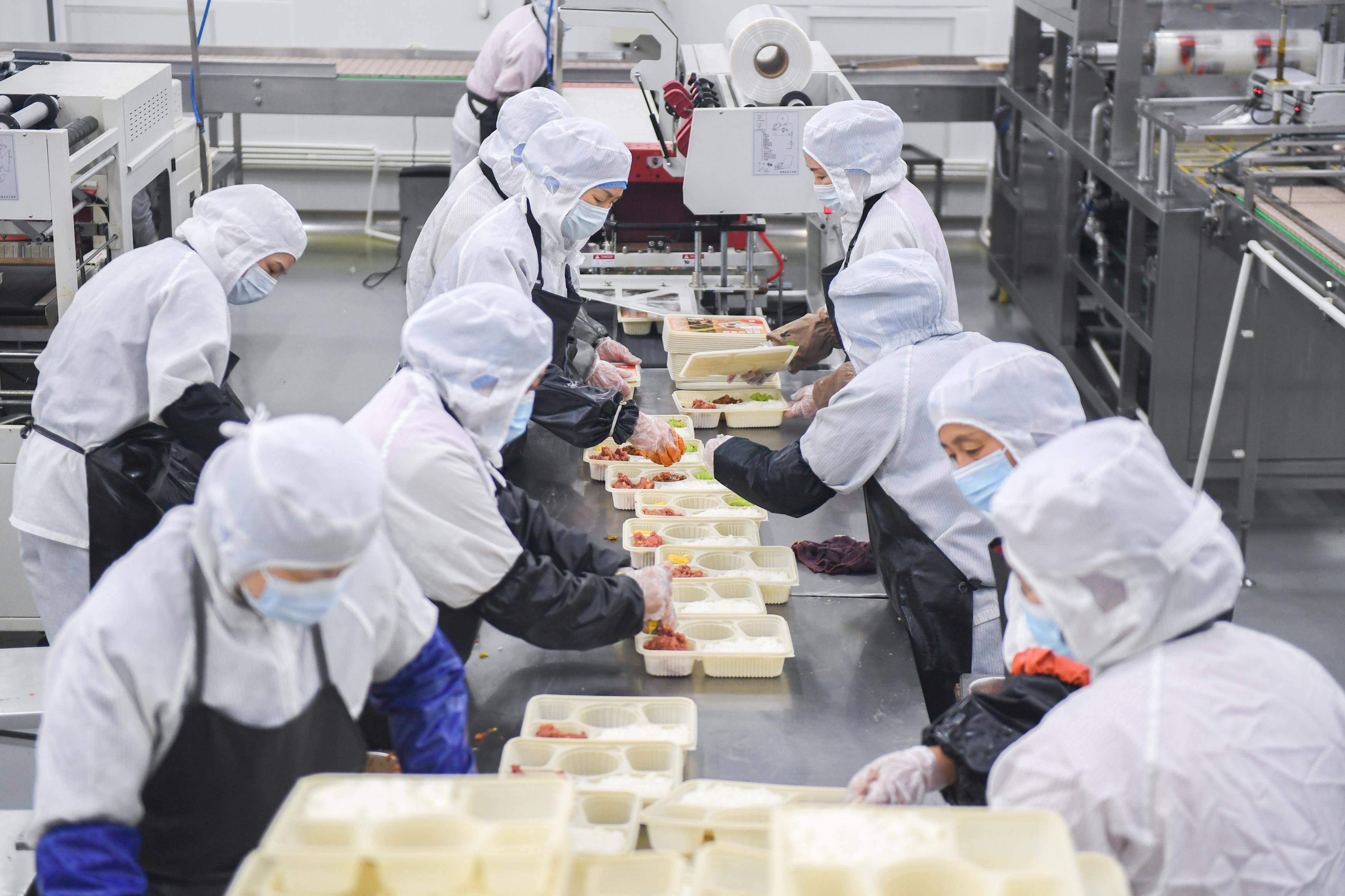 杜子璇 摄1月30日,在武汉铁路餐饮基地,工作人员在分装盒饭