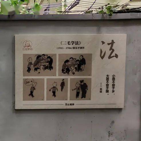 黑色的篱笆墙引人走向弄堂深处,深色的原木大门边上,"张乐平故居"字样