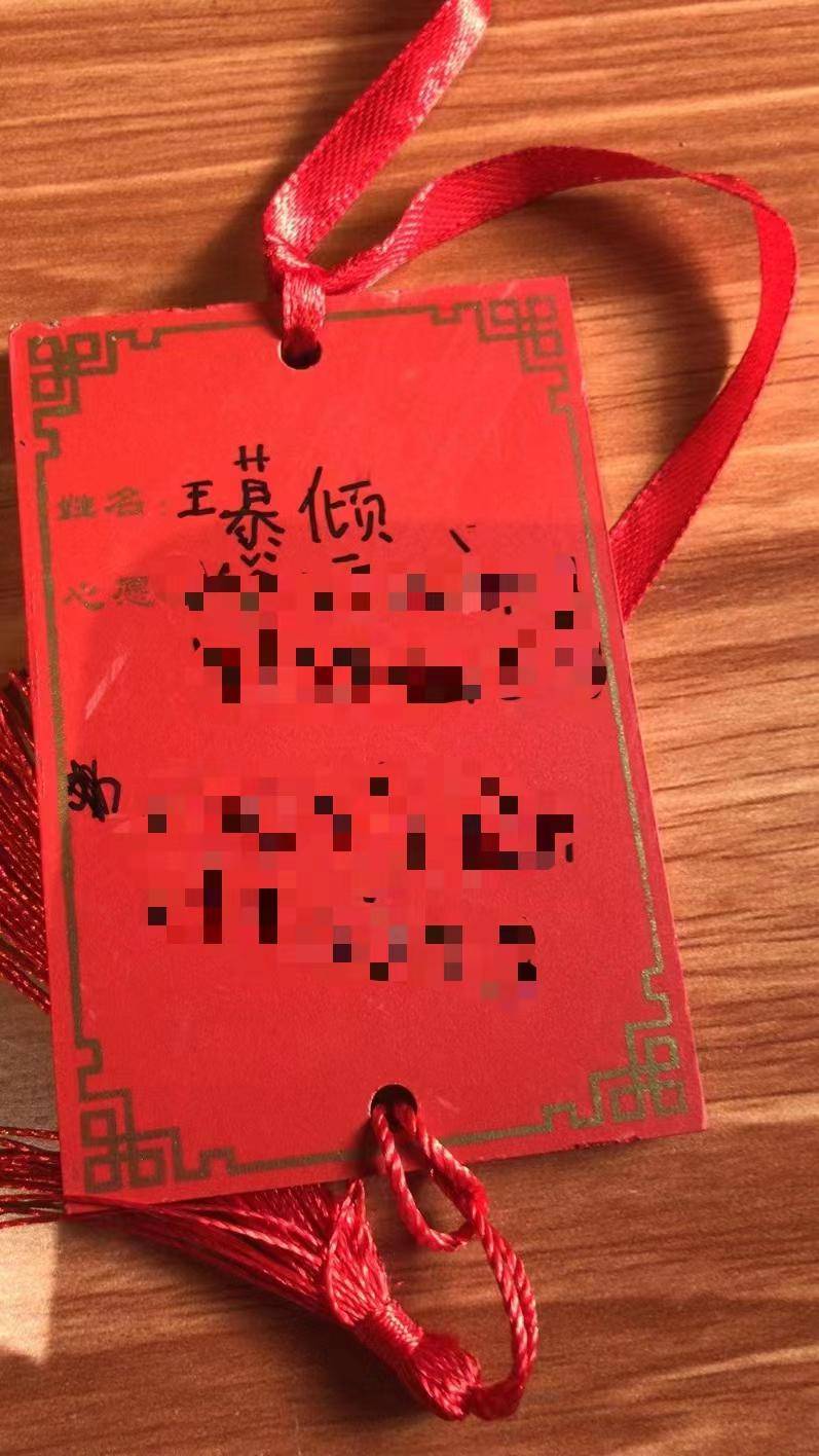 妈妈给我买了一块许愿牌,我模仿前面的小姐姐,也在许愿牌上