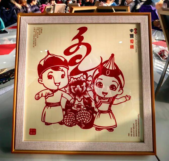 剪出的"十四冬"吉祥物这是来自内蒙古的艺术家洒在一张精美的剪纸上