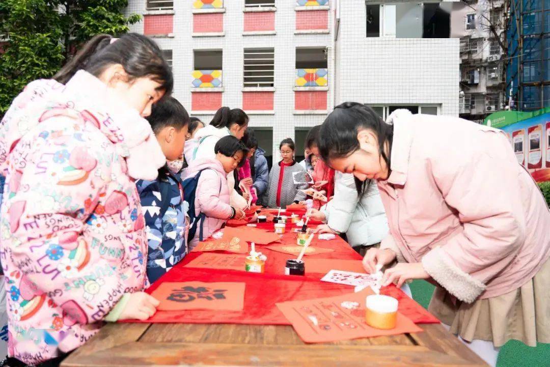返校日,泉州市第二中心小学的老师们手持"龙马精神""龙年大吉"等欢迎