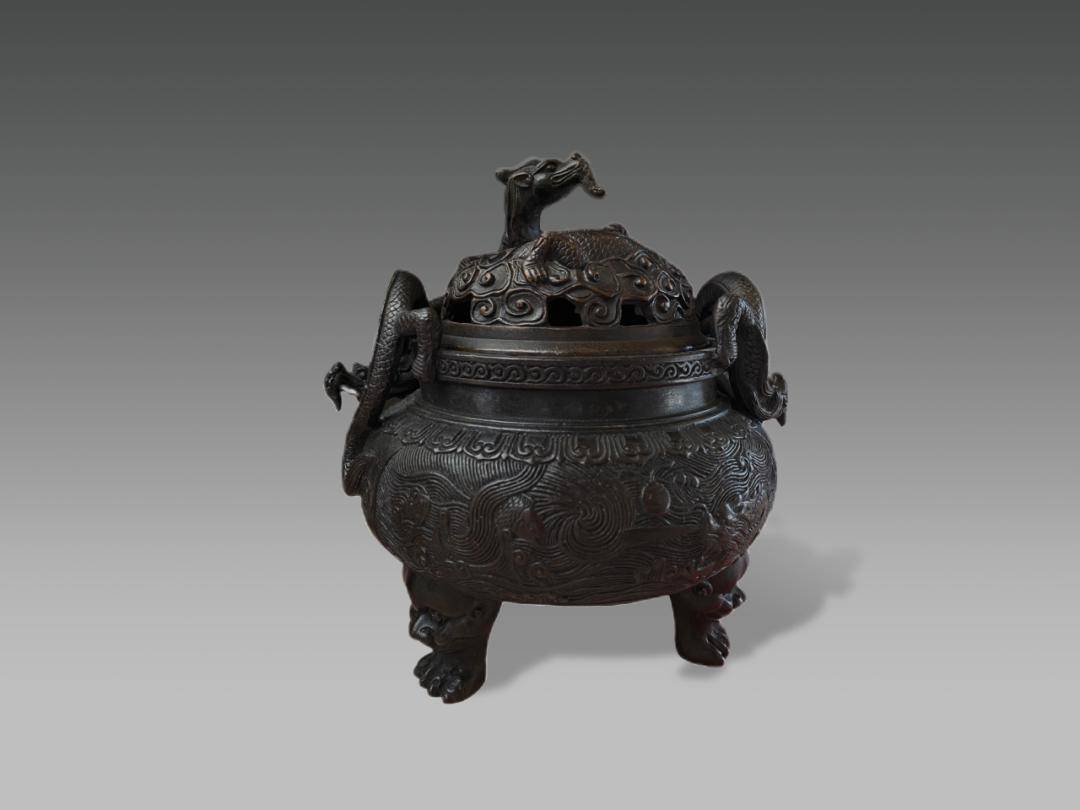 蟠龙耳海龙纹三足炉器型高大厚重,香炉顶盖镂空,鼓盖设计,配合卷云纹