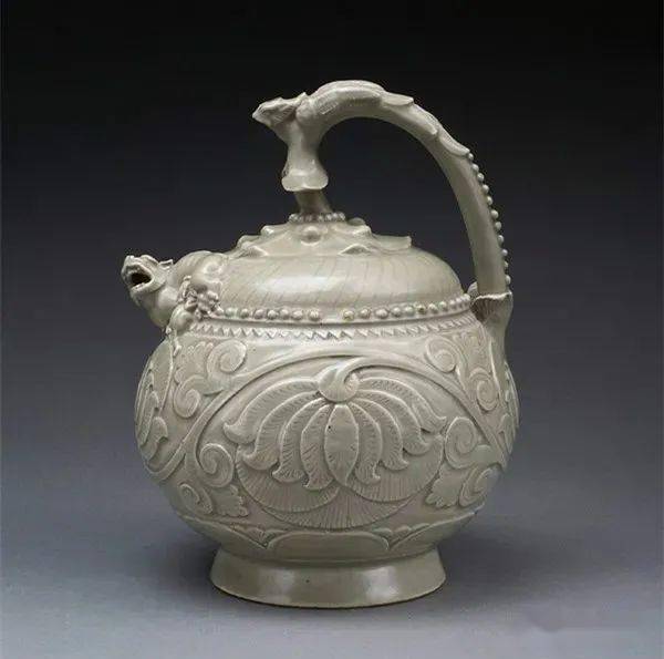 3,五代耀州窑青釉刻花提梁倒流壶碗为直口深腹,外壁饰浮雕莲花三组,盏