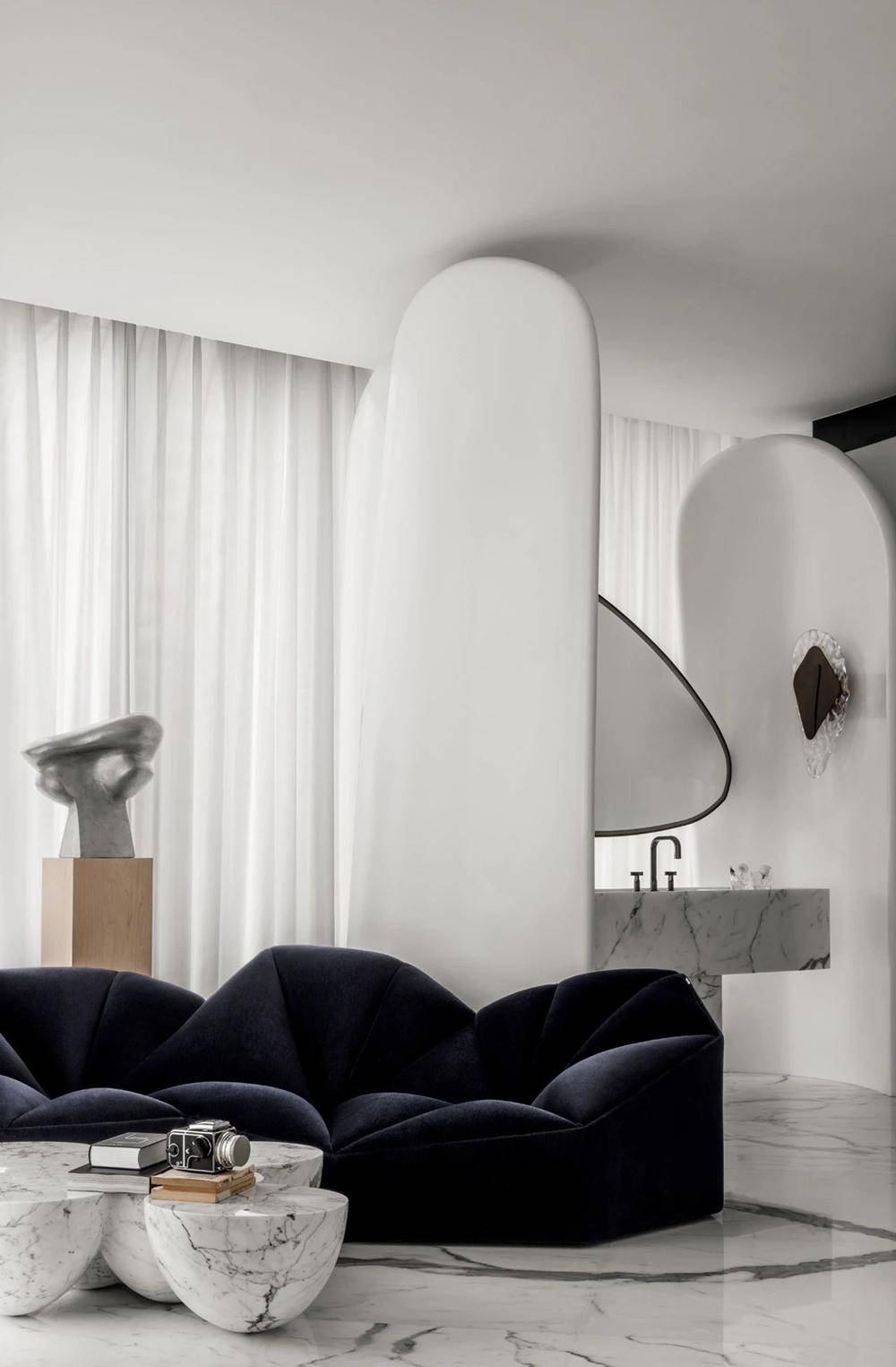 异形多色混拼的地板上,目光所及是浅雕的花卉图案,山丘般的雕塑感沙发