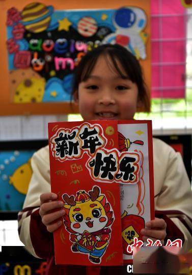 小学生在"二月二龙头节"活动上展示制作的以龙为元素的新年贺卡