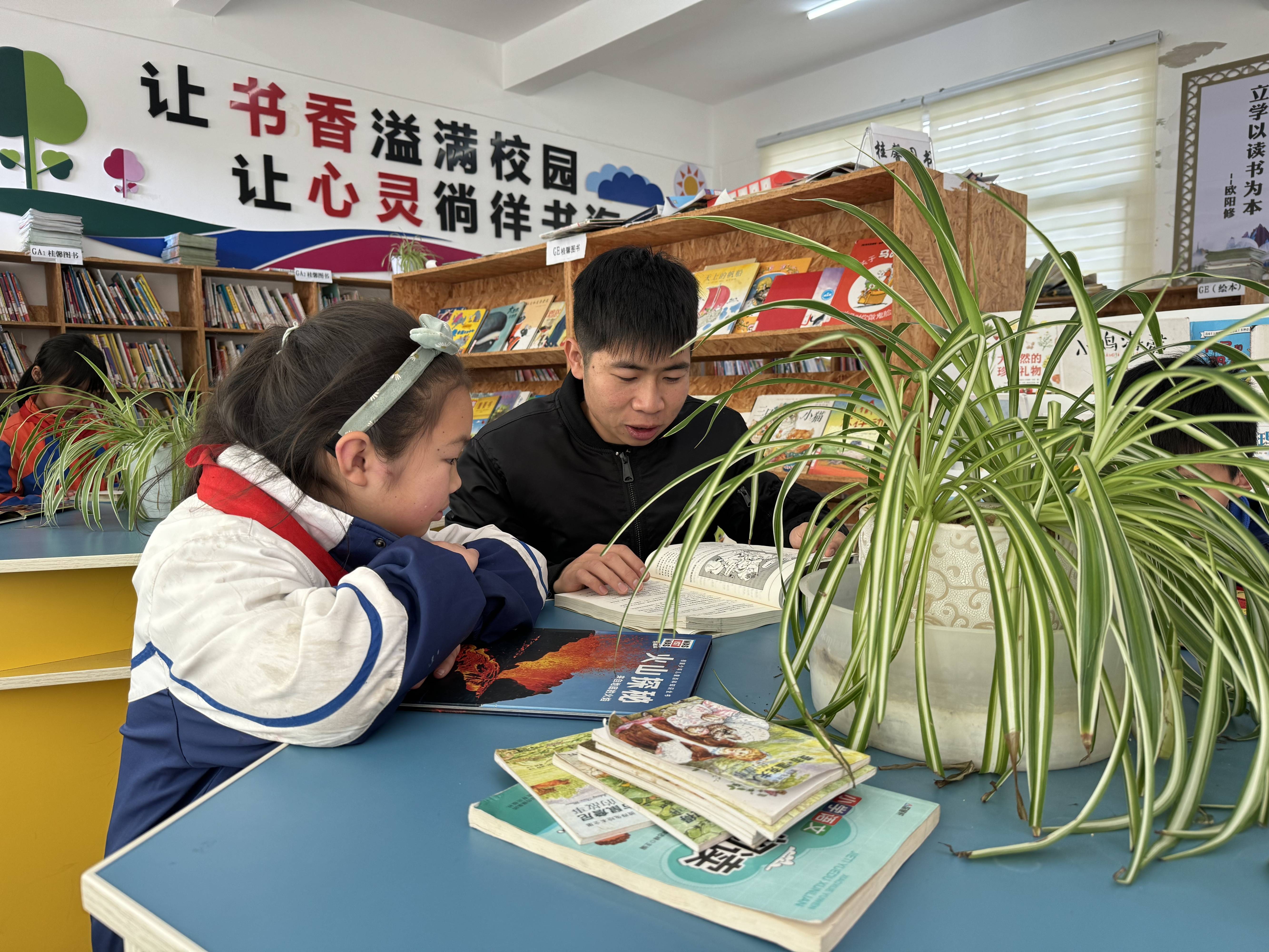 支教老师带领学生共读课外书籍.