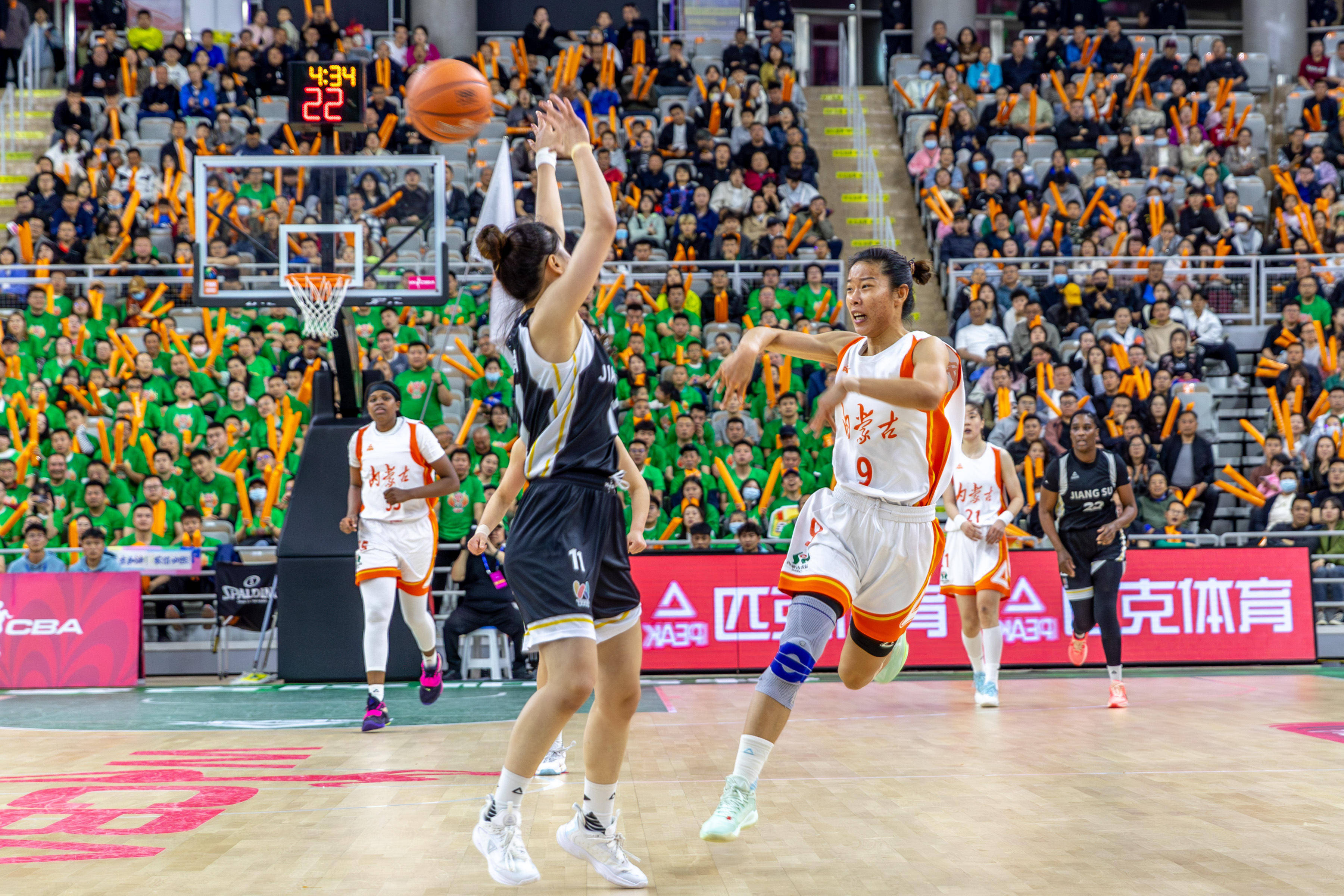 内蒙古农信女篮球员张绮芳(白)在比赛中上篮.