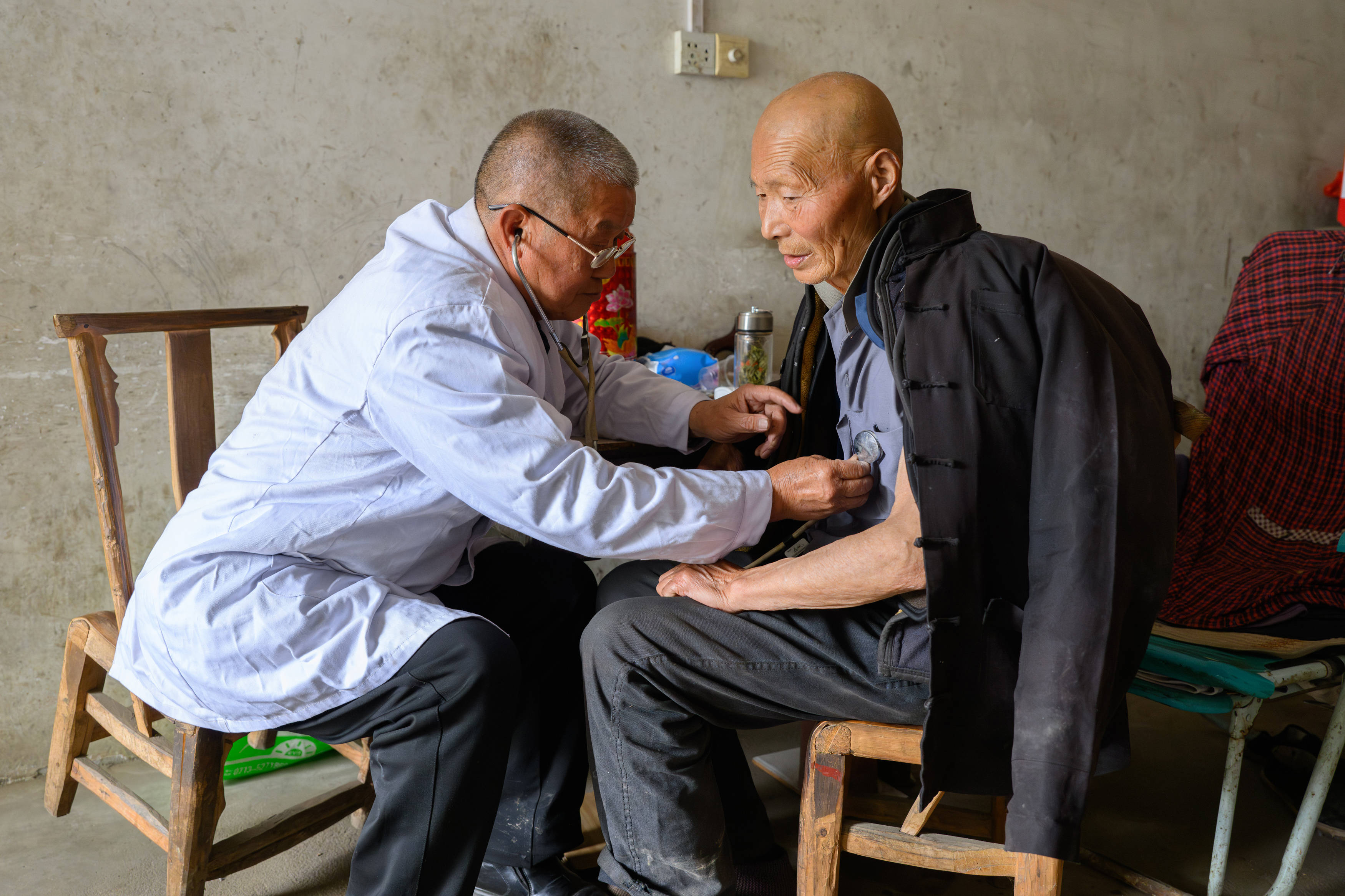 湖北省黄冈市红安县华家河镇大学村,刘昌菊在一户村民家中为村民听诊