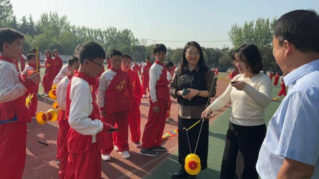 紧接着校长雷红,副校长李俊带领全体参会教师观赏学校"龙行华彩"空竹