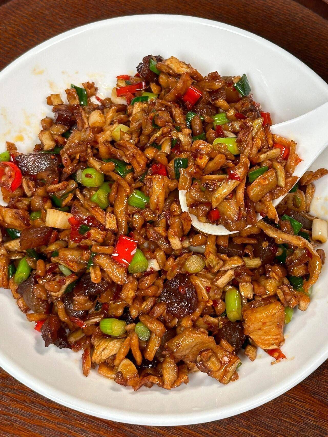 2,把腊肉也是切成比萝卜丁稍微大一点的丁,起锅烧油煸炒出腊肉多余的