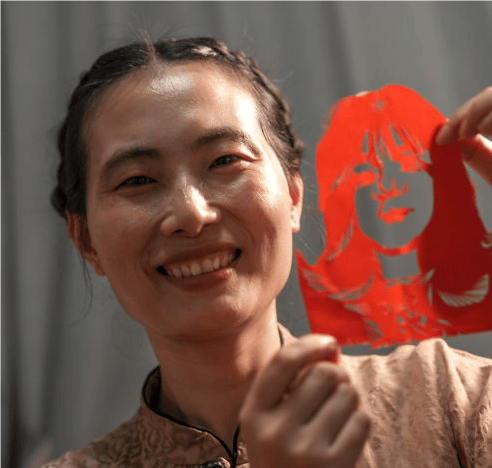 左手红纸,右手剪刀,纸花翻飞间,一张复杂精巧的牡丹图便在徐雪玲手中