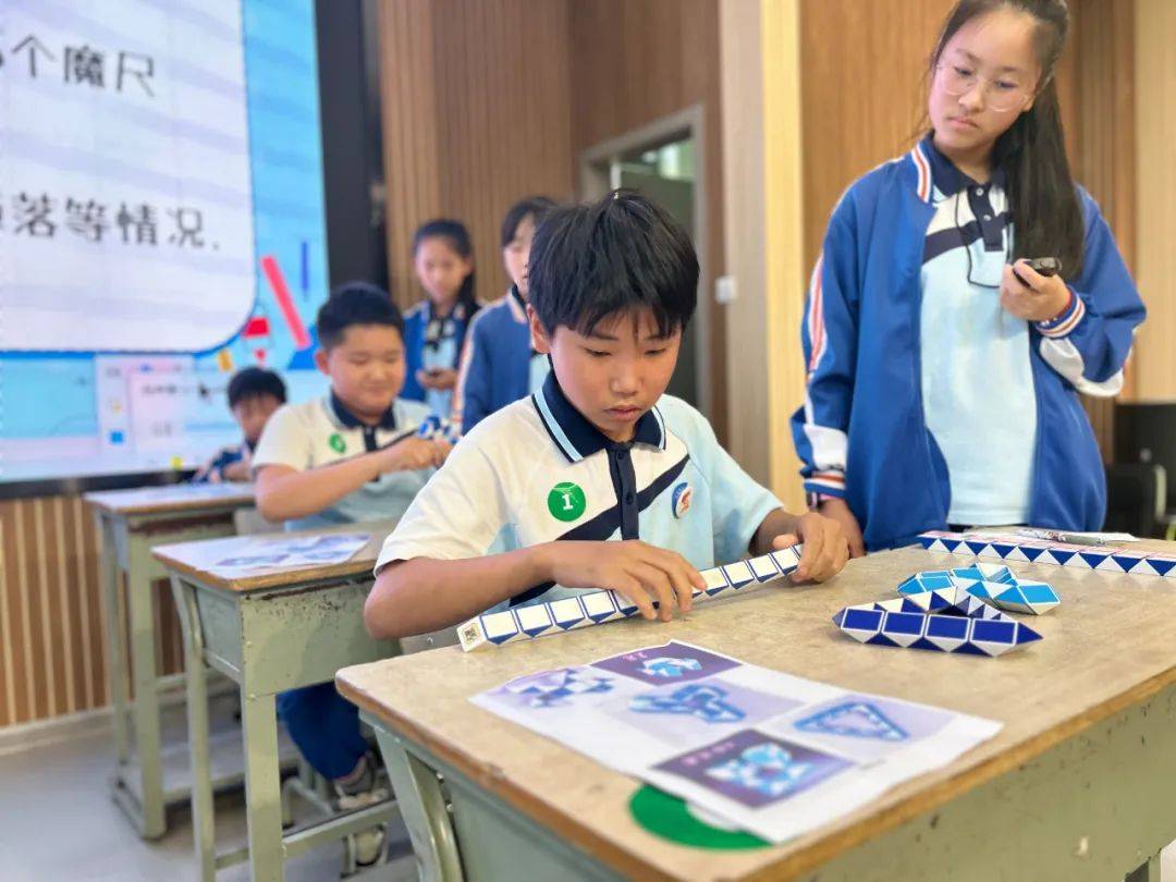 只见魔尺在一双双小手中上下翻飞,在四年级孩子们手中随意扭转,自由拼