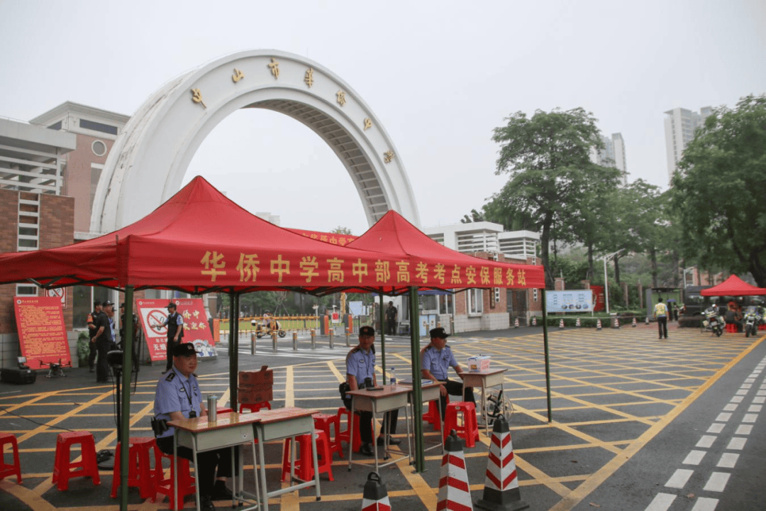 中山市华侨中学△中山市华侨中学的老师在风雨廊下手持kt版为考生们