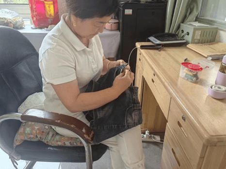 她们帮助每个有需要的同学缝补衣服,专注的表情,细密的针脚,阿姨们用