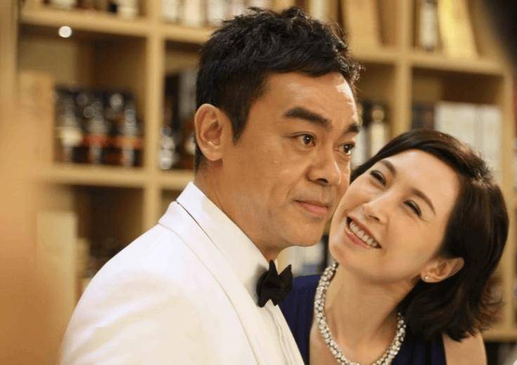 60岁刘青云陪妻子逛街,双手搭其肩头,57岁郭蔼明身姿挺拔不服老